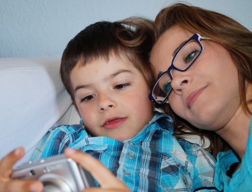 kisfiú telefont néz az anyukájával