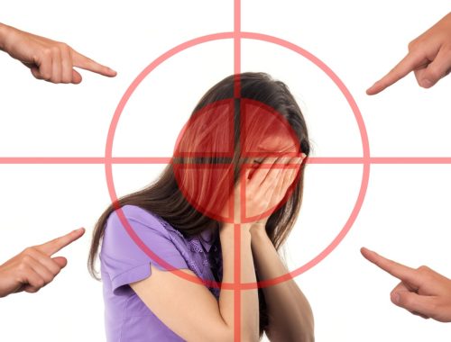 lány eltakarja az arcát, mert ujjal mutogatnak rá