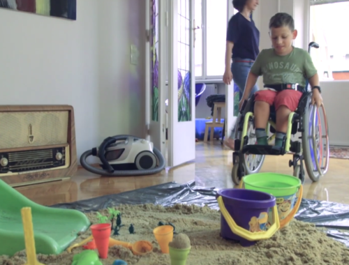 kerekesszékes fiú vödrökkel és csúszdával