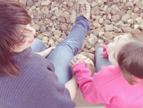 kislány beszélget az anyukájával a kavicsos parton