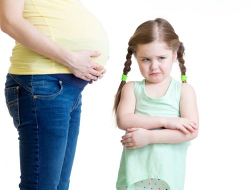 kislány duzzog mellette áll a terhes anyukája