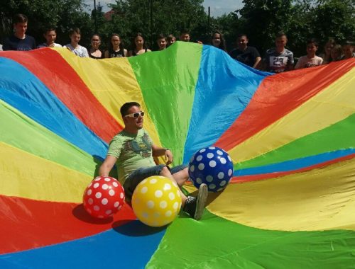 gyerekek kooperációs ernyővel, három pettyes labdával