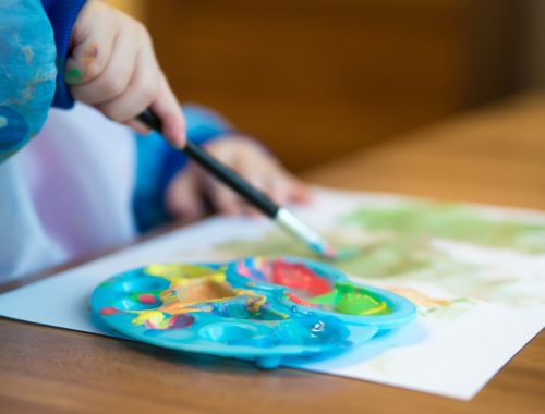 kisgyerek festékkel fest egy paírra