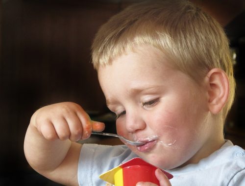 szőke hajú kisfiú eszik kanállal