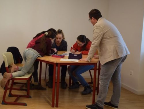 iskolások tanulnak a tanítójukkal