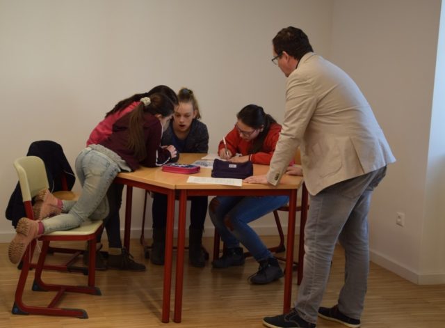 iskolások tanulnak a tanítójukkal