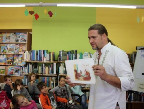 egy férfi képet mutat a gyerekeknek