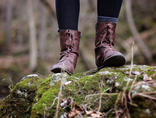 nő bakancsban áll egy sziklán