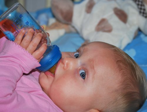 kisbaba cumisüveggel a kezében