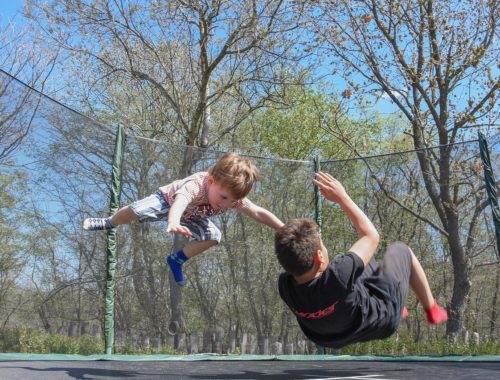 két kisfiú ugrál az ugráló várban