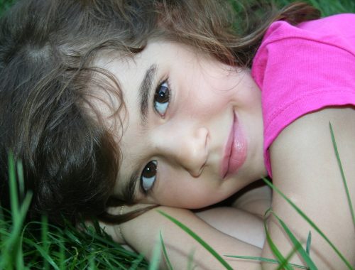 kislány mosolyog a fűben