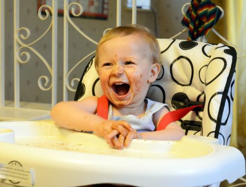 kisfiú maszatos arccal ül az etetőszékben