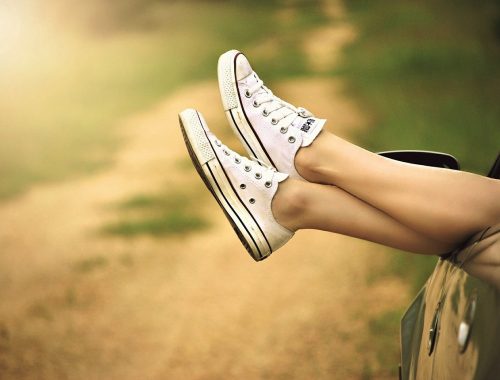 nő kilógatja a lábát az autó ablakán