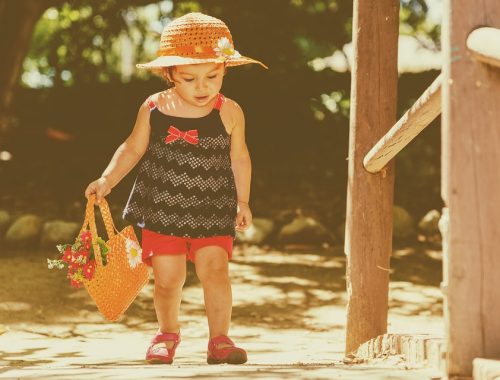 kislány kosár virággal a kezében, kalapban