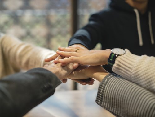 egymásra tett kezek