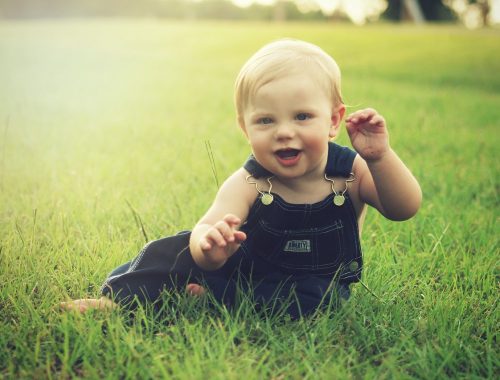 kisgyerek ül a fűben