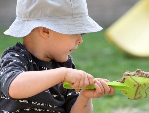 kisfiú homokkal játszik
