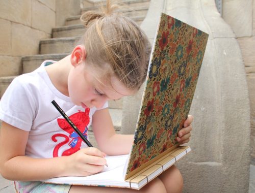 kislány egy füzetbe rajzol