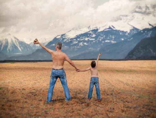apa és fia egy farmernadrágban állnak a mezőn