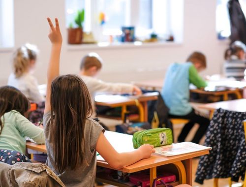 kislány jelentkezik az osztályteremben - óvodai és iskolai jelentkezés